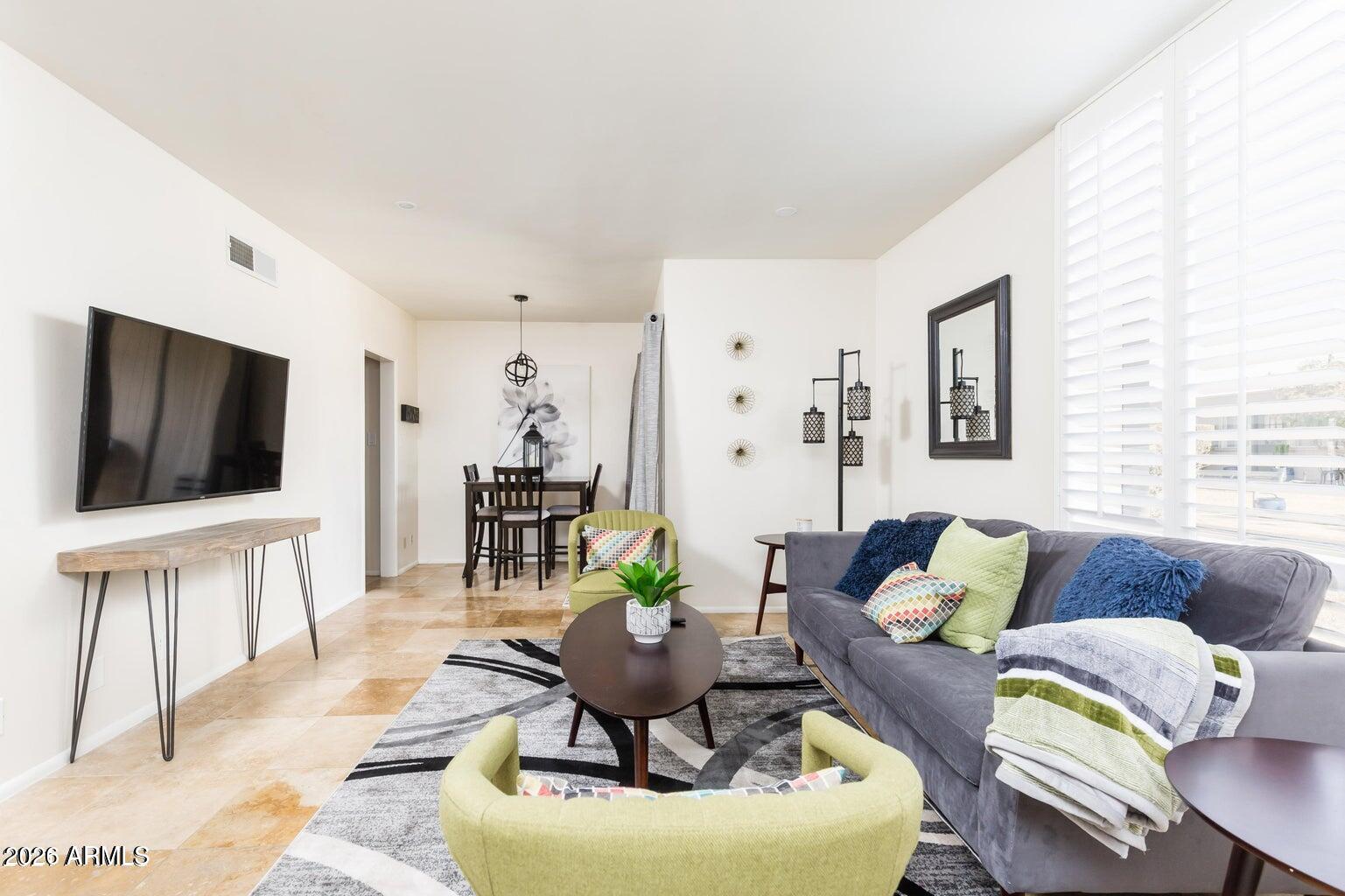 3242 East Camelback Road, Unit 104 Phoenix, AZ 85018 - Photo 5 of 19 a living room with furniture and a flat screen tv