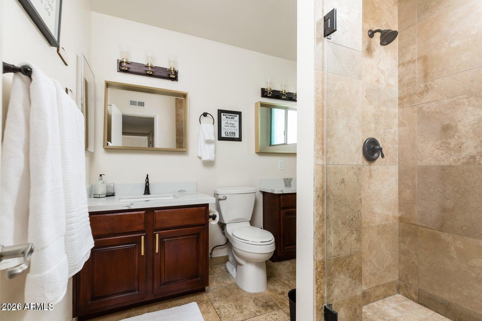 3242 East Camelback Road, Unit 104 Phoenix, AZ 85018 - Photo 9 of 19 a bathroom with a toilet a sink and a mirror