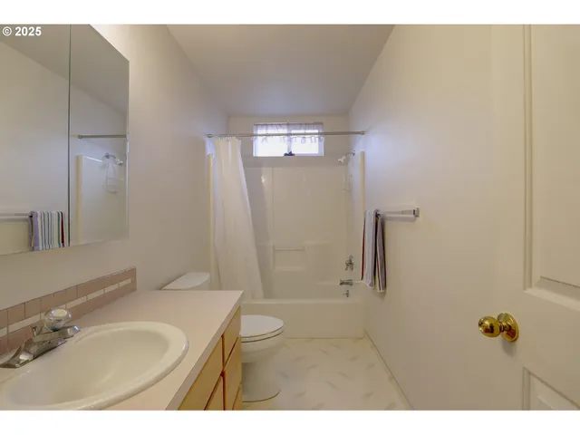 a bathroom with a granite countertop sink a mirror and shower