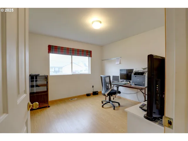 a view of a workspace with furniture and a window