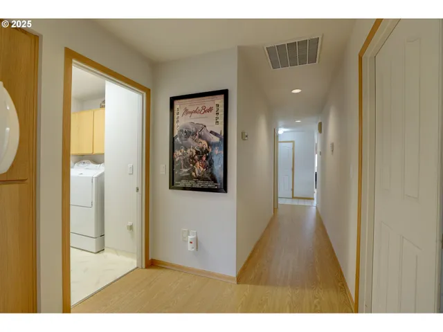 a view of a hallway with a large window with wooden floor