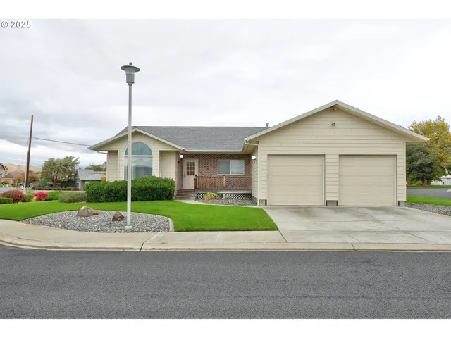 a front view of a house with a garden and garage