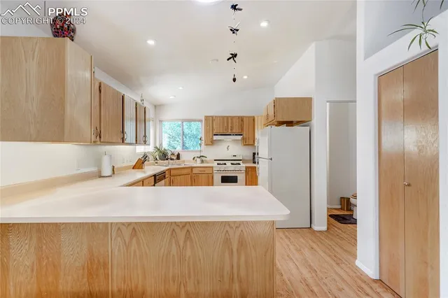 a kitchen with appliances a sink and cabinets
