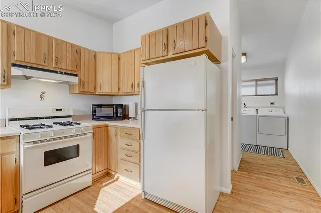 a kitchen with granite countertop wooden cabinets a sink and dishwasher