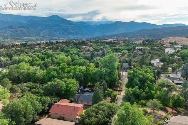 an aerial view of residential house with outdoor space and trees all around