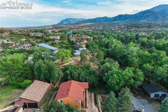 an aerial view of a house with a garden and trees