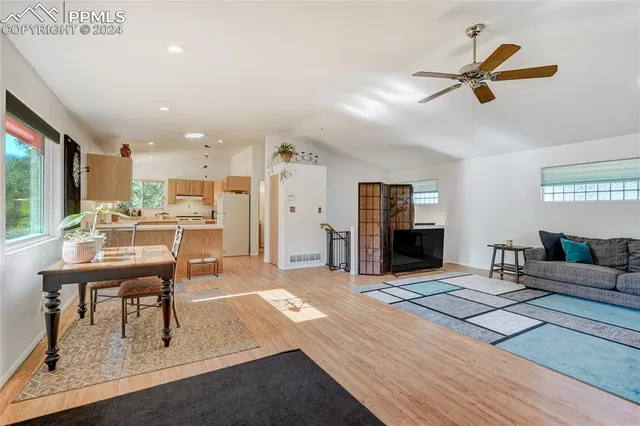 a living room with furniture a flat screen tv and a table