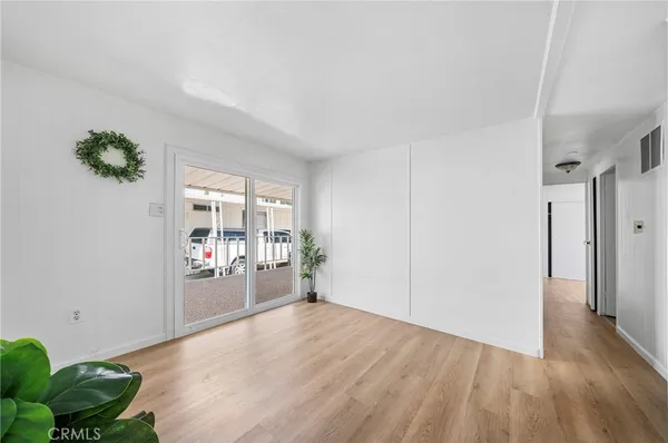 a view of a livingroom with wooden floor and natural light