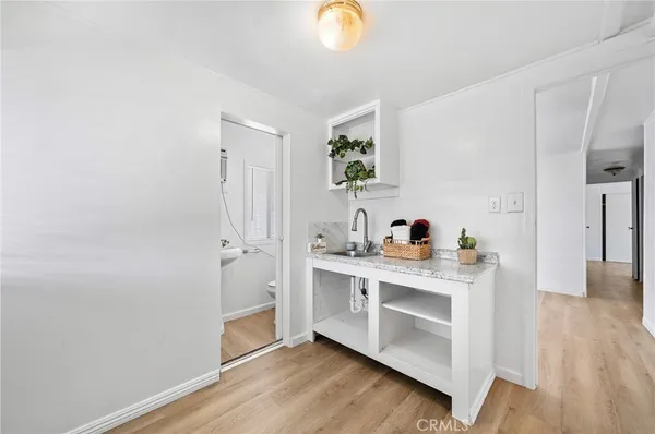a view of cabinets a oven a wooden floor and a window