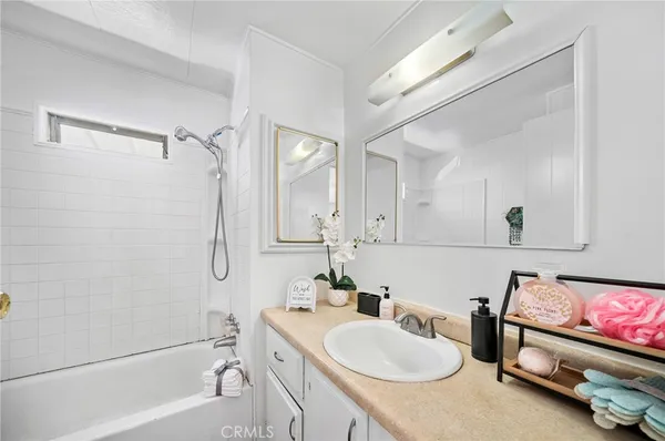 a bathroom with a tub a sink and mirror