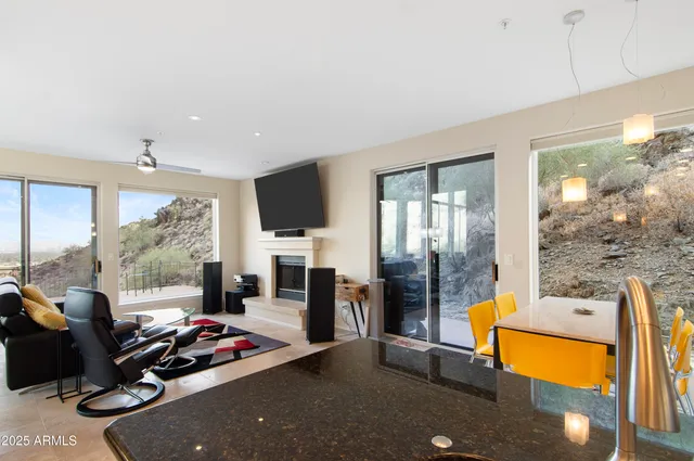 a living room with furniture a flat screen tv and a floor to ceiling window