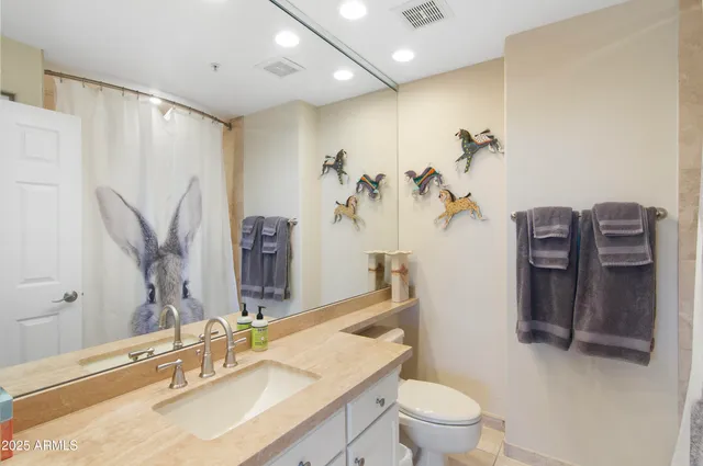 a bathroom with a granite countertop sink a toilet and a mirror