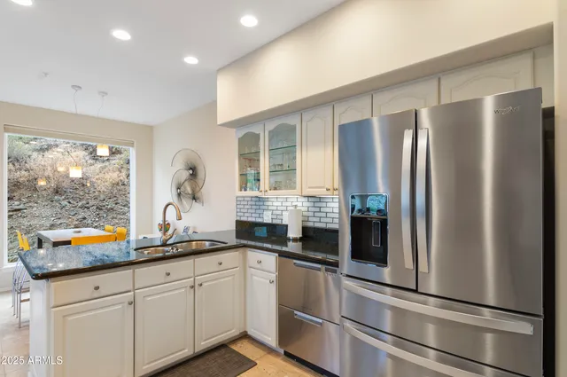 a kitchen with stainless steel appliances granite countertop a refrigerator and a sink