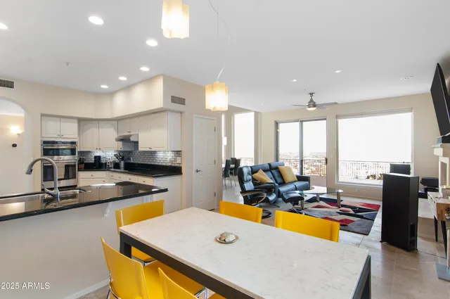 a kitchen with stainless steel appliances granite countertop a sink dishwasher and a refrigerator with wooden floor