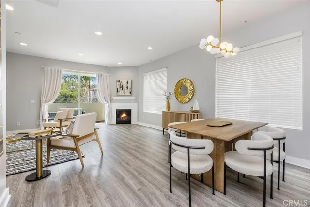 a view of a dining room with furniture a chandelier and wooden floor