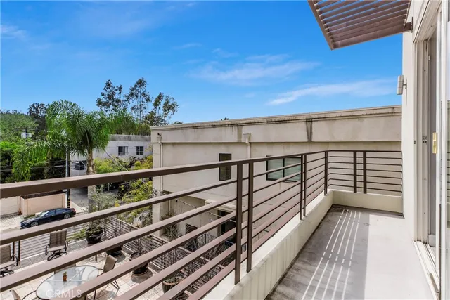 a view of a balcony with wooden floor and fence
