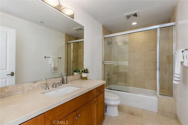 a bathroom with a granite countertop sink a toilet and shower