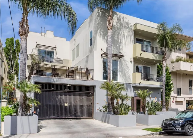 a front view of a building with a garden and plants
