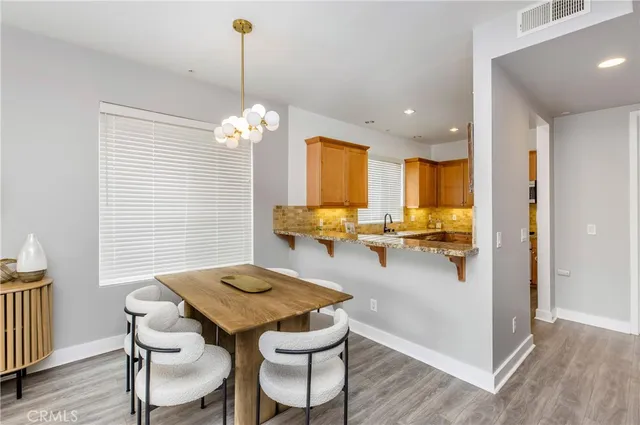 a dining room filled chandelier and wooden floor
