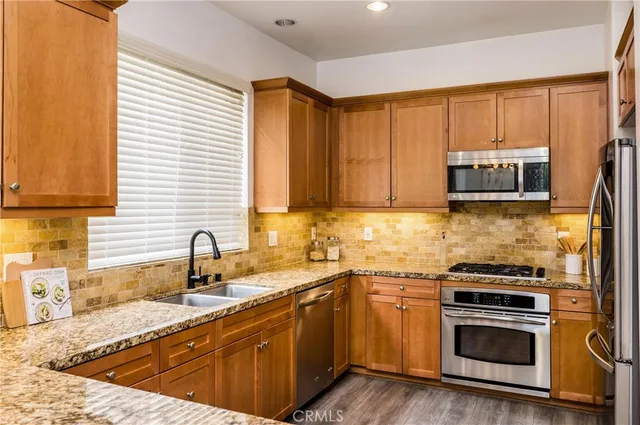 a kitchen with stainless steel appliances a stove sink and microwave