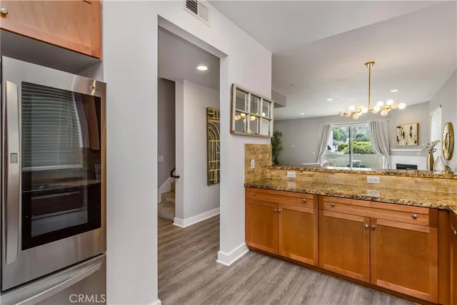a kitchen with stainless steel appliances granite countertop a refrigerator a sink and a stove