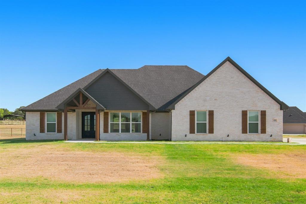 121 Friendship Way Boyd, TX 76023 - Photo 1 of 38 Contemporary single-story residence featuring a light-colored brick exterior, a dark shingle roof, and a prominent gable design