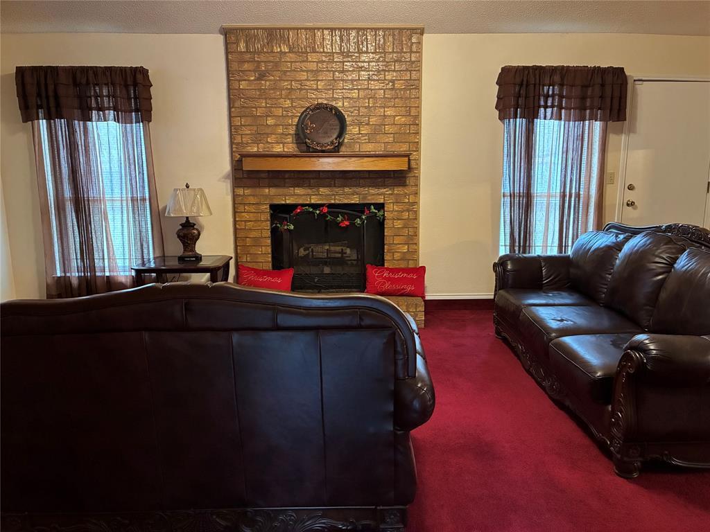 8430 Retta Mansfield Road Mansfield, TX 76063 - Photo 12 of 17 a living room with furniture and a fireplace