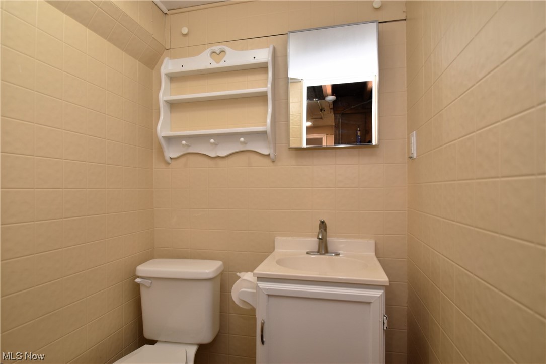 13300 Rockside Road Garfield Heights, OH 44125 - Photo 25 of 32 Bathroom featuring tile walls, large vanity, and toilet
