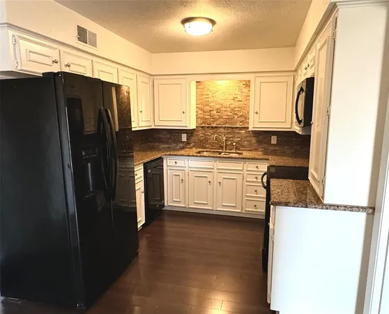 a kitchen with stainless steel appliances a refrigerator a sink and wooden cabinets