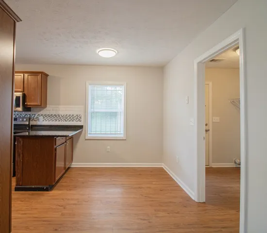 a view of kitchen with granite countertop cabinets and black appliances