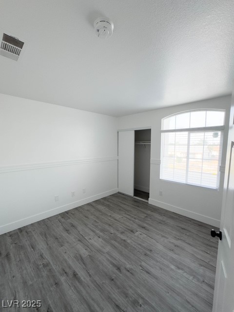 3686 Lincoln Road Las Vegas, NV 89115 - Photo 18 of 26 Unfurnished bedroom with dark wood-type flooring, a closet, visible vents, and baseboards