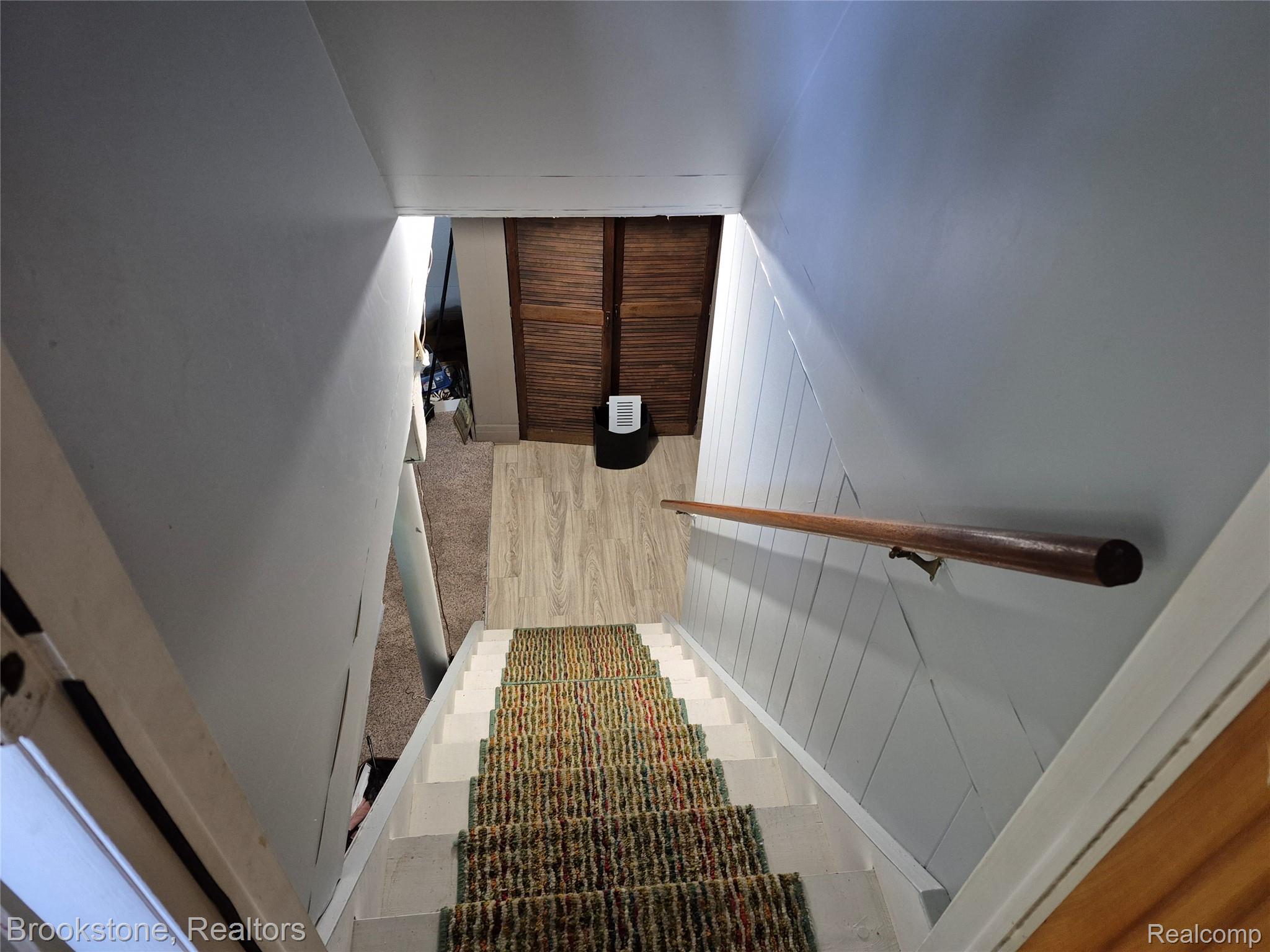 4295 Sashabaw Road Waterford, MI 48329 - Photo 27 of 37 Staircase featuring a patterned carpet runner, white risers, and a wooden handrail
