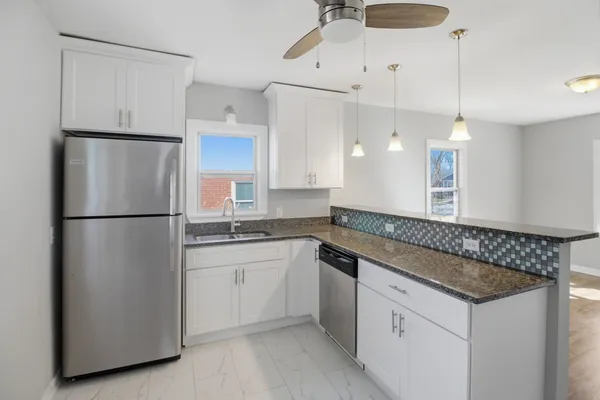 a kitchen with a refrigerator a sink and cabinets