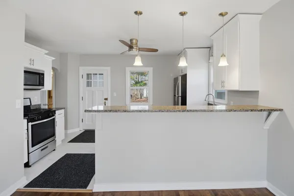 a kitchen with stainless steel appliances granite countertop a sink a stove and a refrigerator