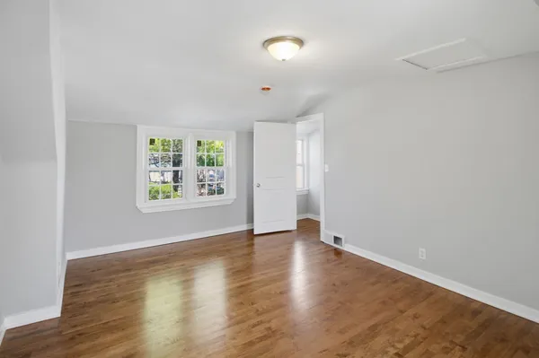 an empty room with window and wooden floor