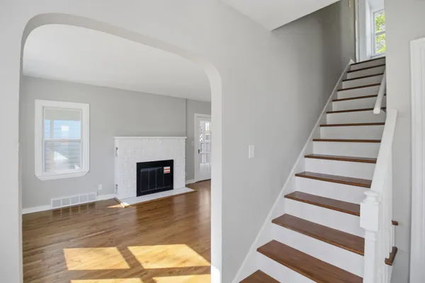a view of a livingroom with wooden floor fireplace and windows