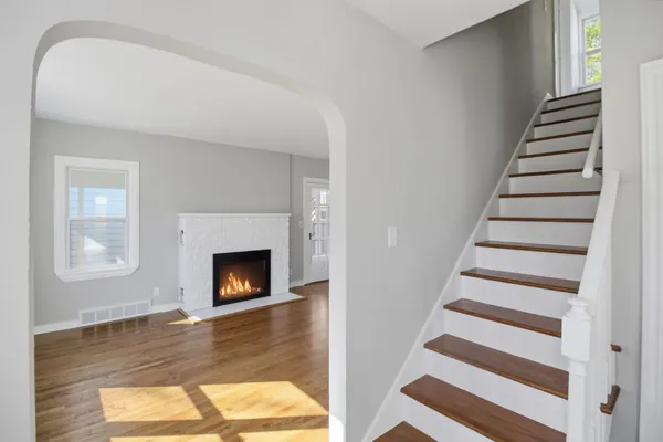 a view of a livingroom with wooden floor and a fireplace