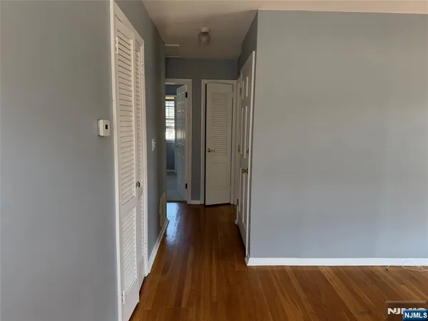 a view of a big room with wooden floor and entryway