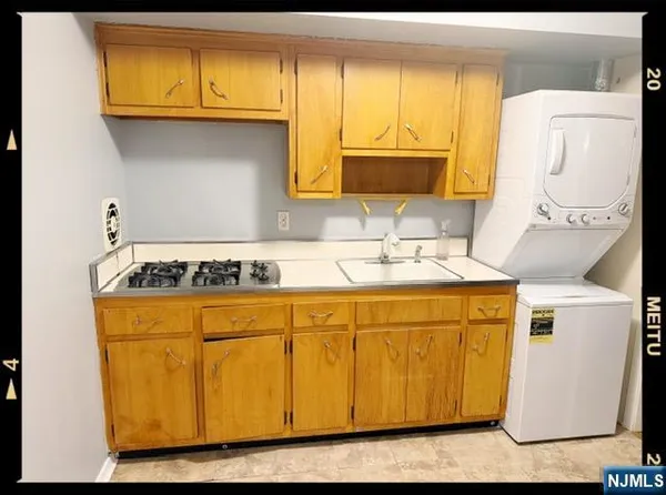 a bathroom with a granite countertop sink and washing machine
