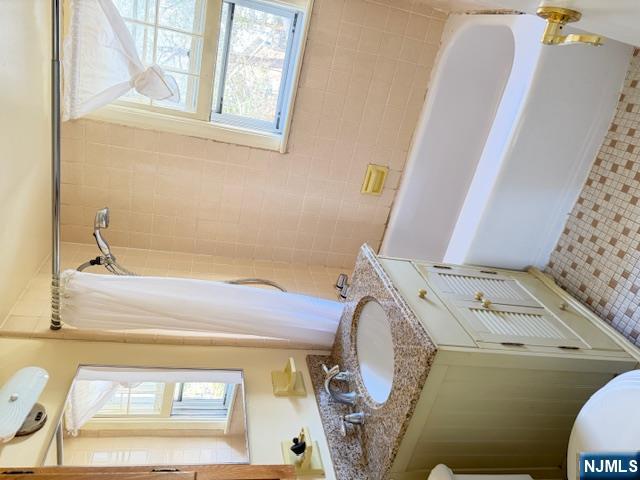 39 Franklin Street, Unit 2 Tenafly, NJ 07670 - Photo 9 of 27 a bathroom with a granite countertop sink and a mirror