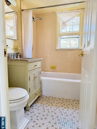 a bathroom with a granite countertop sink toilet a mirror and a bathtub