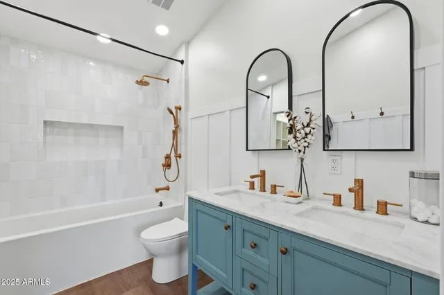 a bathroom with a granite countertop sink a toilet and a mirror