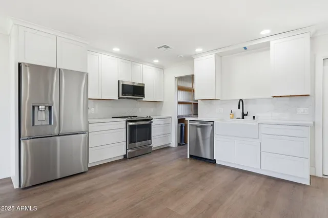 a kitchen with stainless steel appliances a refrigerator sink and cabinets
