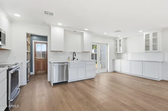a kitchen with white cabinets and stainless steel appliances