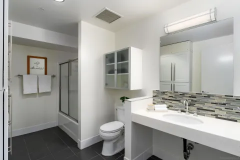 a bathroom with a double vanity sink toilet and mirror