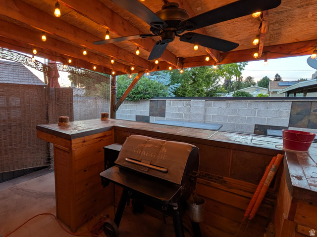 8252 Wood Street Midvale, UT 84047 - Photo 28 of 40 Covered patio featuring an exposed wood beam ceiling, string lighting, and a ceiling fan