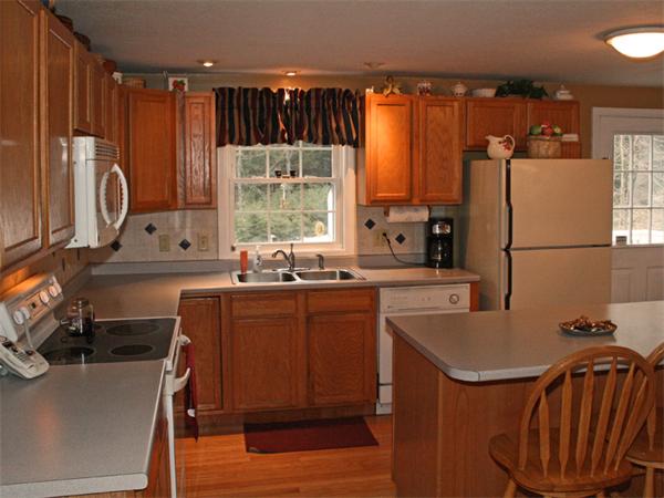 65 Young Road Ashburnham, MA 01430 - Photo 2 of 22 a kitchen with stainless steel appliances granite countertop a refrigerator a sink dishwasher a stove with wooden cabinets and a large window
