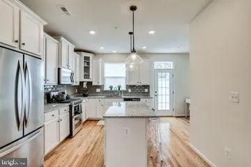 a kitchen with stainless steel appliances granite countertop a sink refrigerator and cabinets