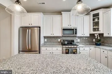a kitchen with granite countertop a stove and a refrigerator