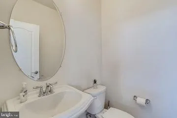 a bathroom with a sink a toilet and mirror